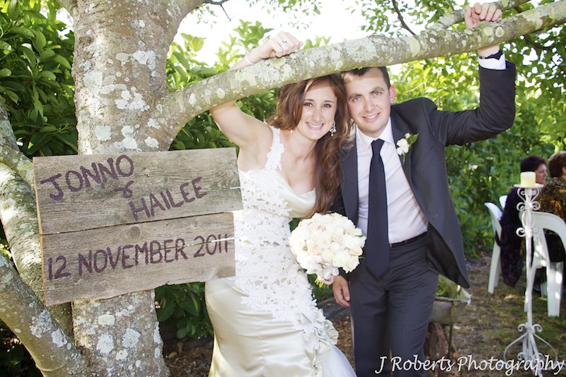 Bride and groom with wedding sign at garden party wedding - wedding photography sydney